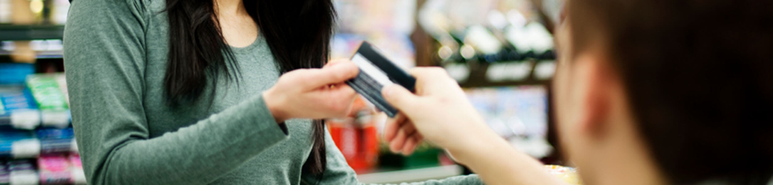 women handing a card to a cashier