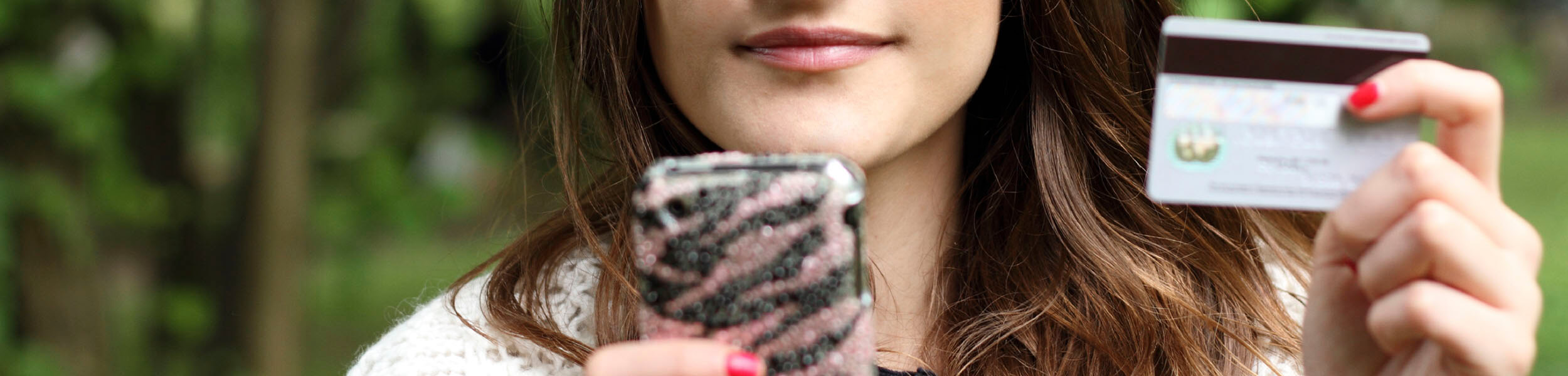 girl looking at phone with card